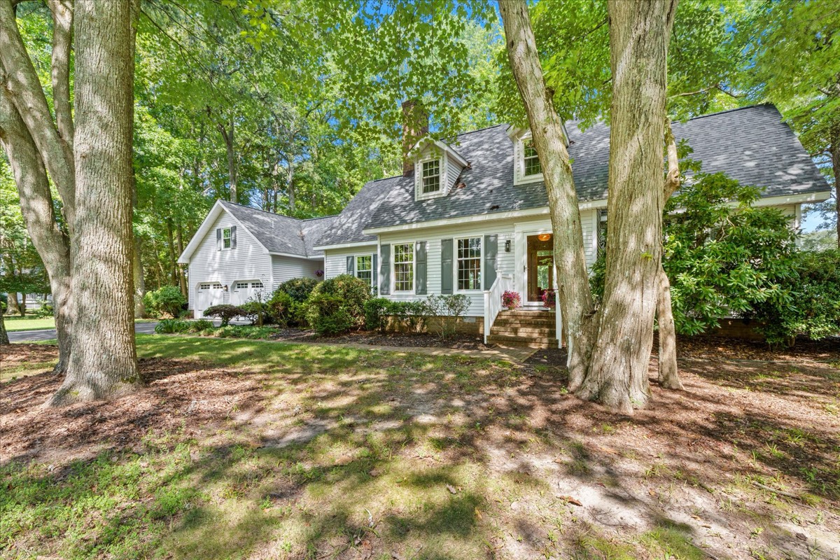 Front of home nestled among mature trees